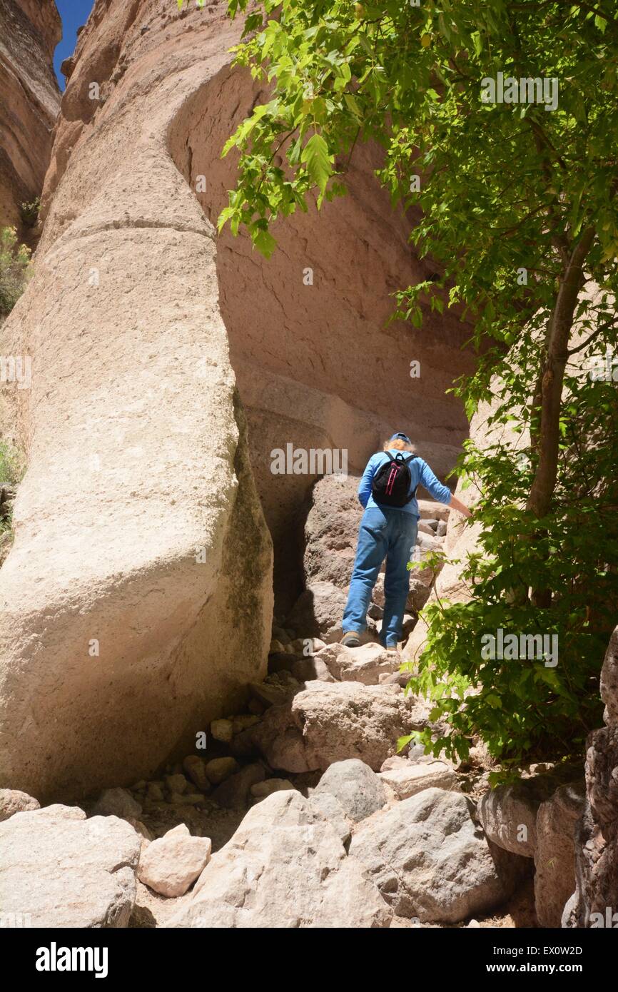 Senior female climbing boulder strewn area at Kasha-Katuwe Tent Rocks National Monument New Mexico - USA Stock Photo