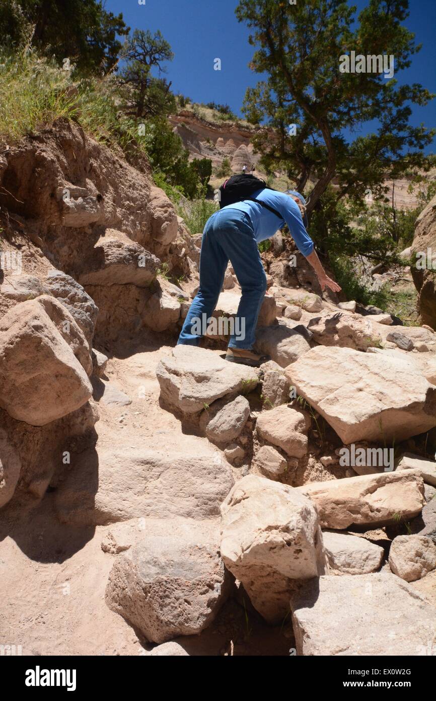Senior Citizen climbing boulders on trail Kasha-Katuwe Tent Rocks National Monument New Mexico - USA Stock Photo