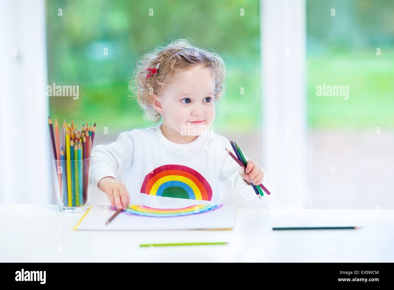 Funny Laughing Baby Girl Drawing With Colorful Pencils At A White