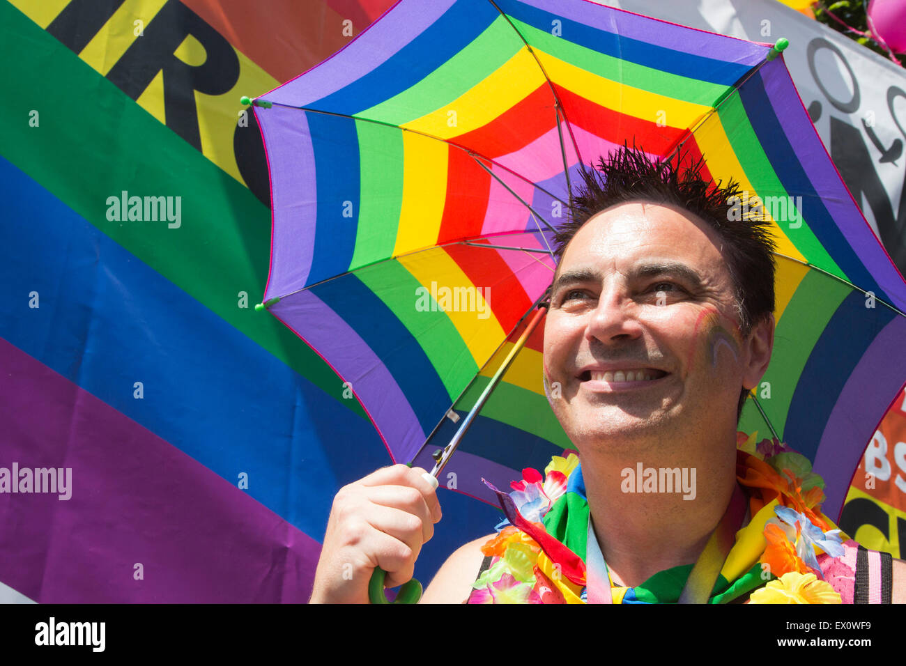 Man holding a rainbow coloured umbrella at the LGBT Pride in London Parade. Stock Photo