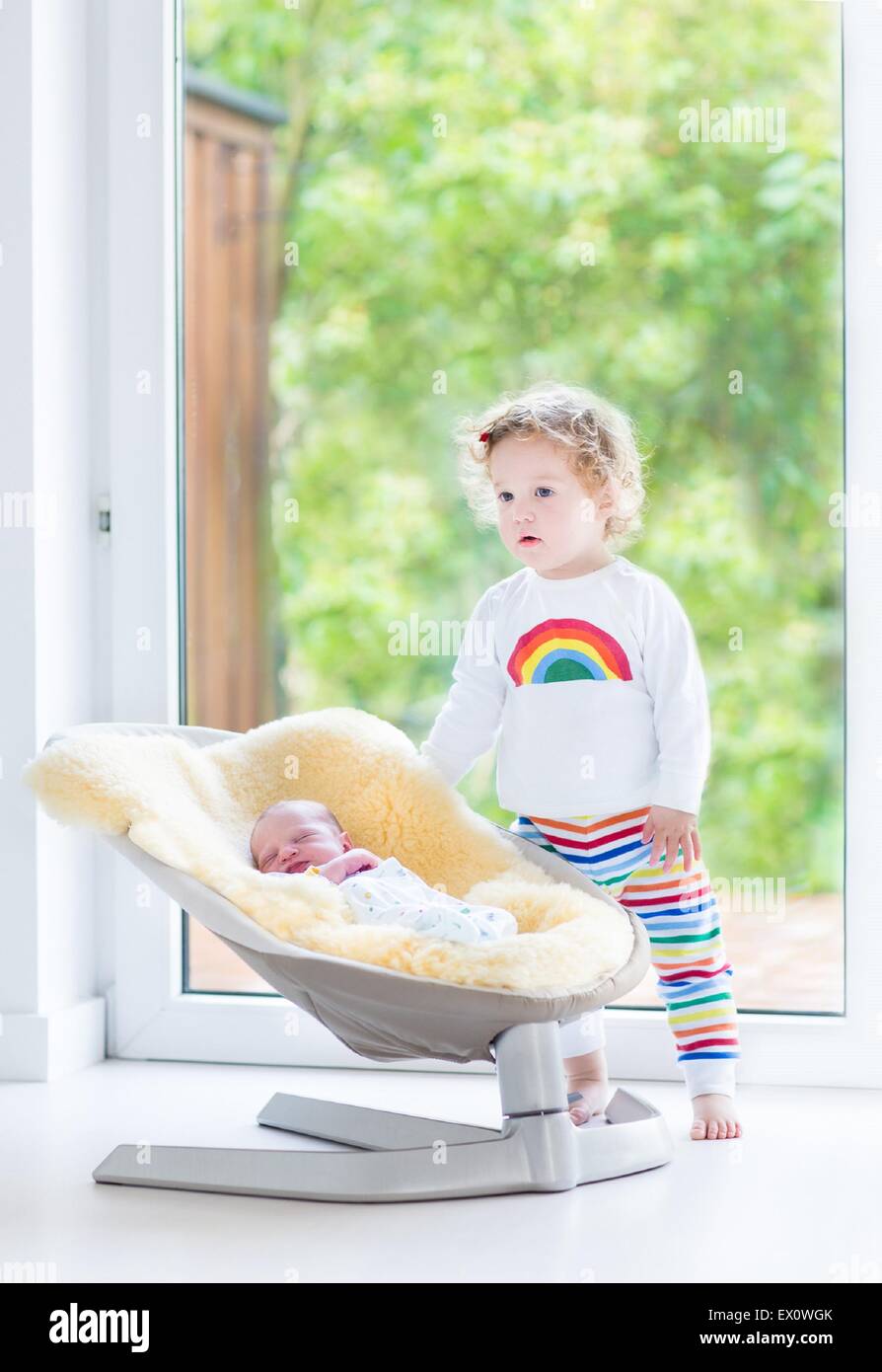 Cute Toddler Girl Playing With Her Newborn Baby Brother Relaxing In A Swing Next To A Big Window And Door To The Garden Stock Photo Alamy Cute Toddler Girl Playing With Her Newborn Baby Brother Relaxing In A Swing Next To A Big Window And Door To The Garden Stock Photo Alamy