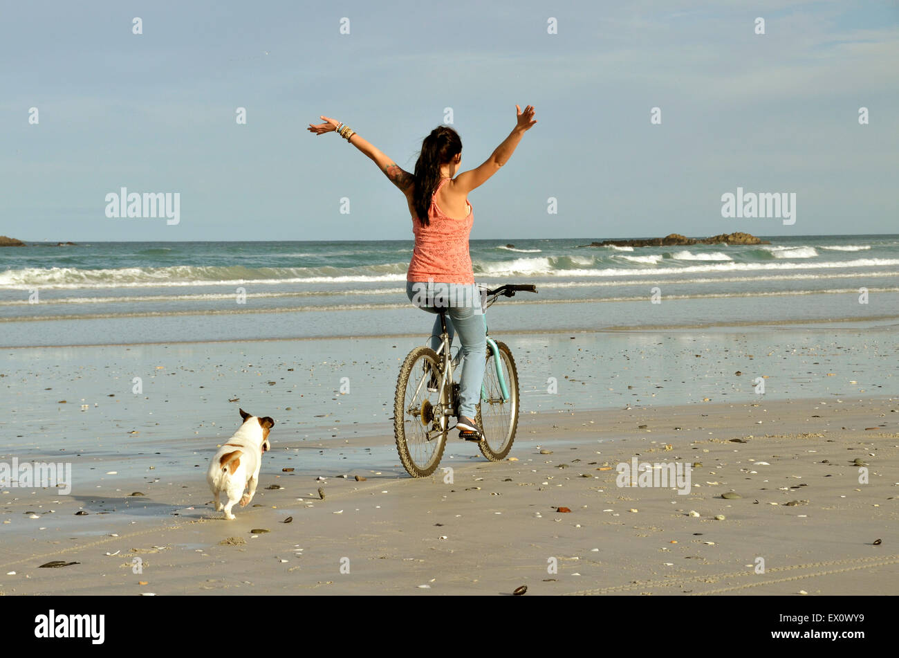 girl riding a bike on a beach Stock Photo