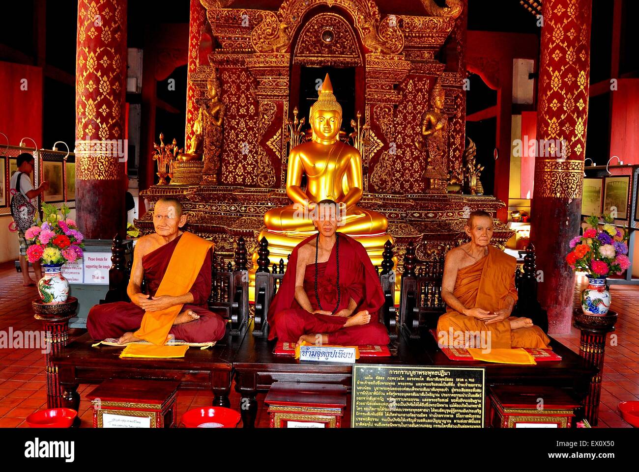 Chiang Mai, Thailand :  Opulent interior of the Lanna style Phra Wihan Lai Kham with wax effigies of three monks Stock Photo