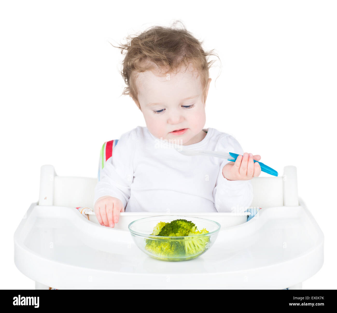 Cute Funny Toddler In A White High Chair Eating Her Vegetables For