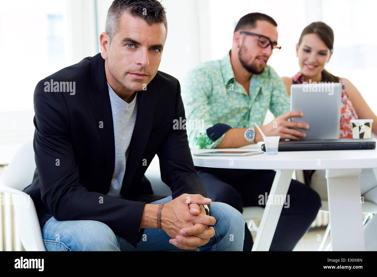 Portrait of confident businessman in office with his team. Stock Photo