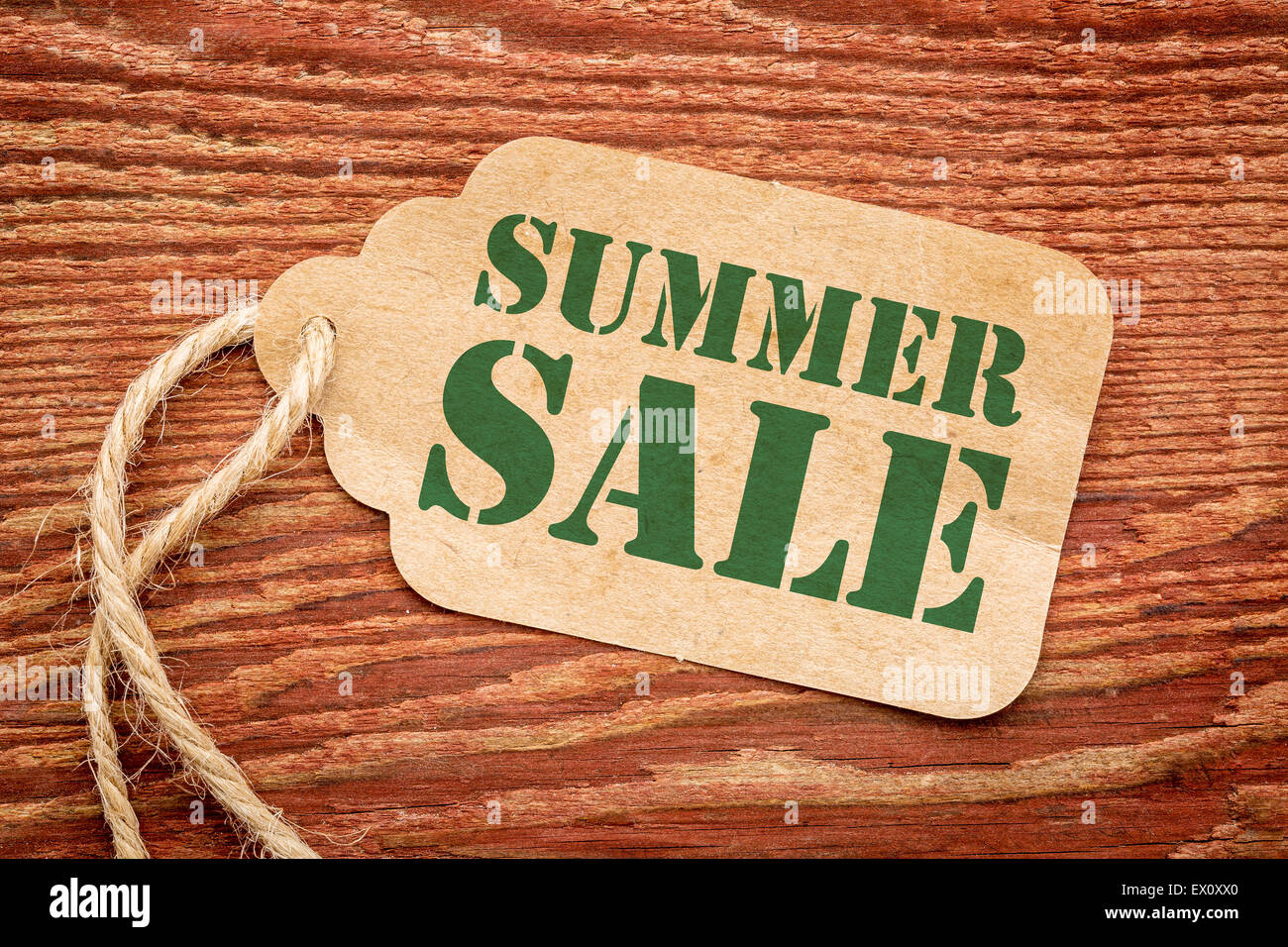 summer sale sign - a paper price tag against rustic red painted barn ...