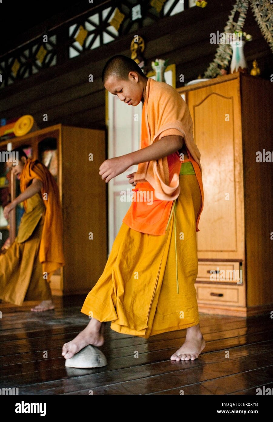 Young monks clean the floor of their living quarters at  Wat Si Muang, Vientiane, Laos, P.D.R. Stock Photo