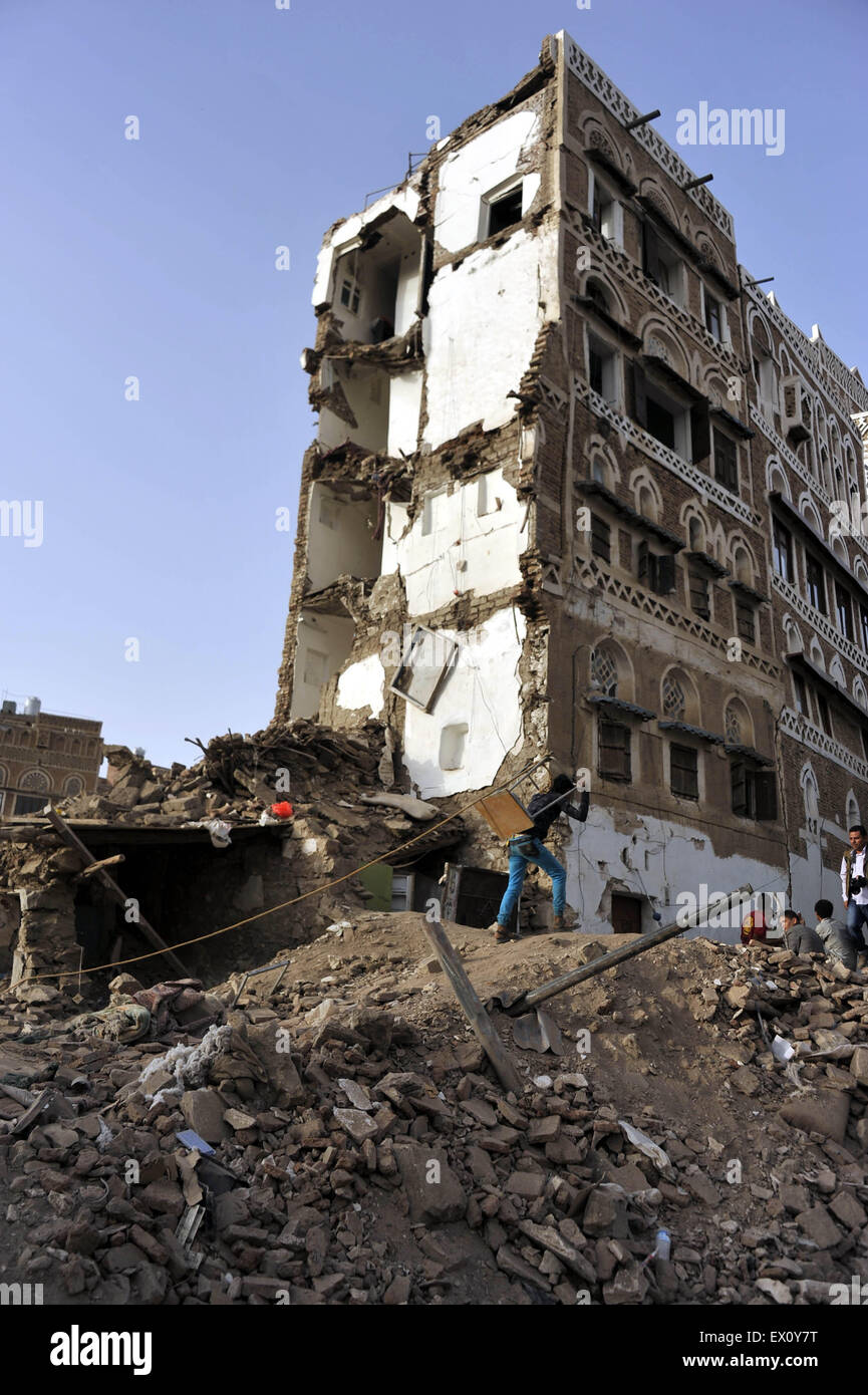 Sanaa, Yemen. 3rd July, 2015. Yemenis walk near a historical building destroyed by the airstrike of Saudi-led coaltion forces in the Old City of Sanaa in Sanaa, Yemen, on July 3, 2015. The United Nations Educational, Scientific and Cultural Organization (UNESCO) World Heritage Committee on July 2 added two sites in Yemen on the List of World Heritage in Danger: the Old City of Sanaa and the Old Walled City of Shibam. Credit:  Hani Ali/Xinhua/Alamy Live News Stock Photo