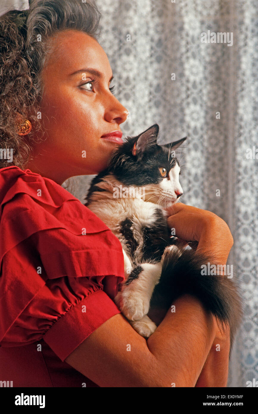 Young Latin-American woman cuddling male kitten Stock Photo