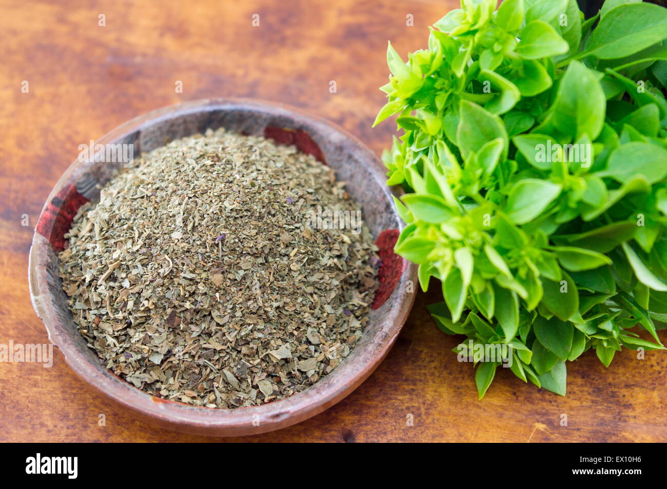 Dried and fresh basil arranged on a table in old kitchen bowl Stock Photo