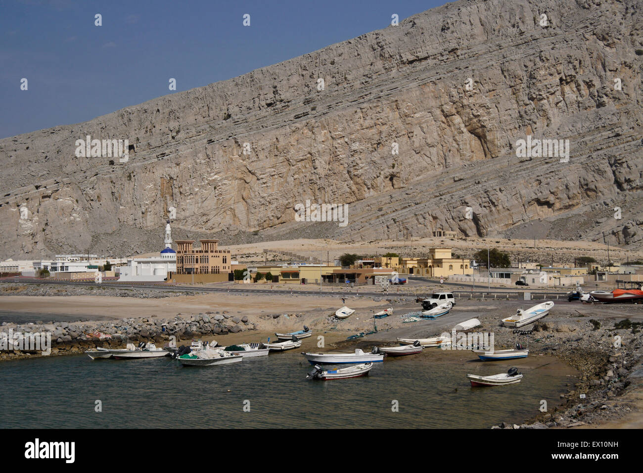 Rocky landscape and village with fishing boats, Musandam Peninsula, Oman Stock Photo