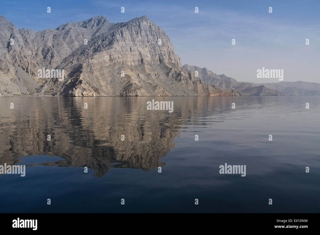 Rocky mountains reflected in the waters of a khor (fiord), Musandam Peninsula, Oman Stock Photo