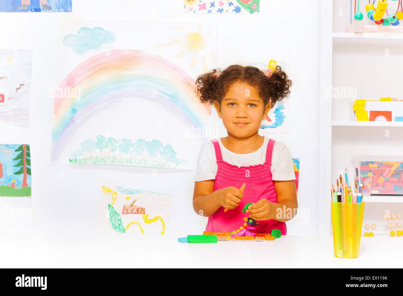 Little girl play with modeling clay in classroom Stock Photo