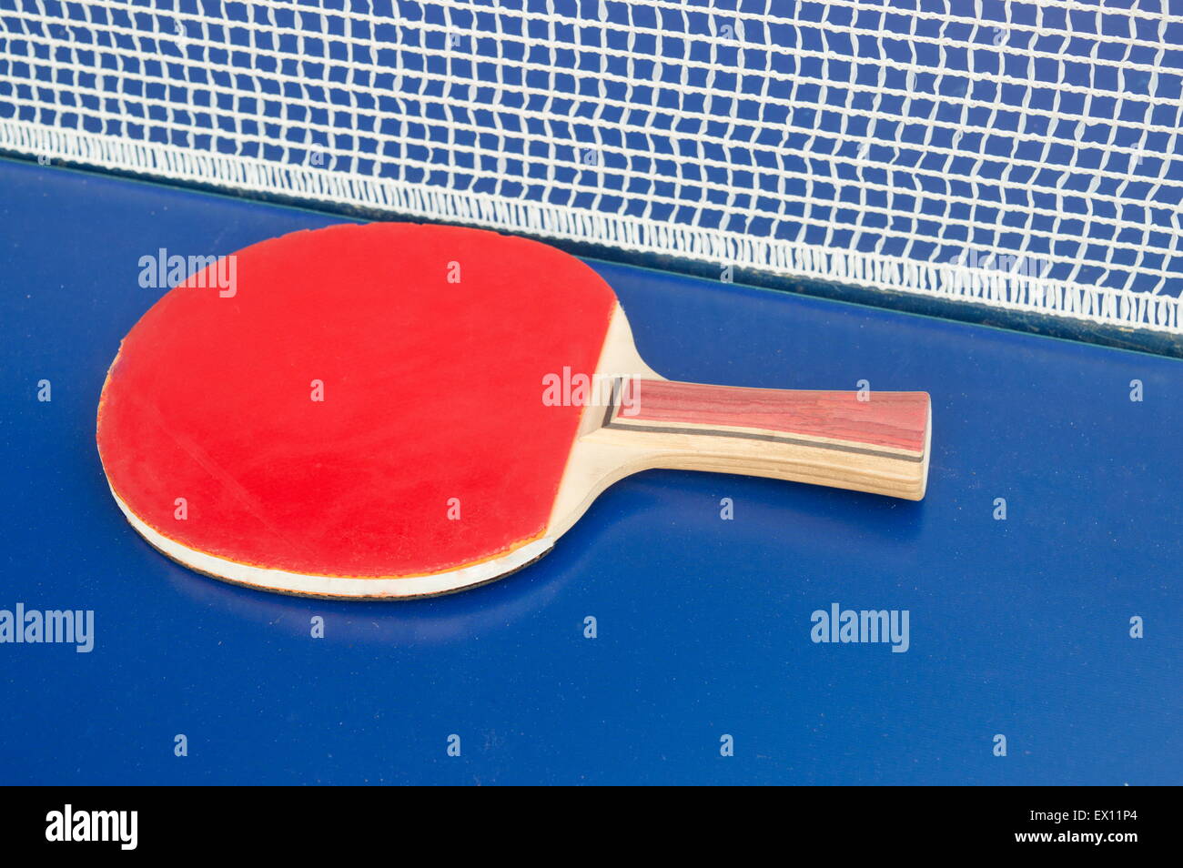 Table tennis racket and net on a blue table tennis table Stock Photo