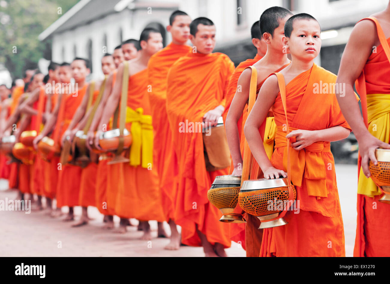 Monks processing for alms in the early morning, a 1,000-year old tradition in Luang Prabang, Laos.. Stock Photo