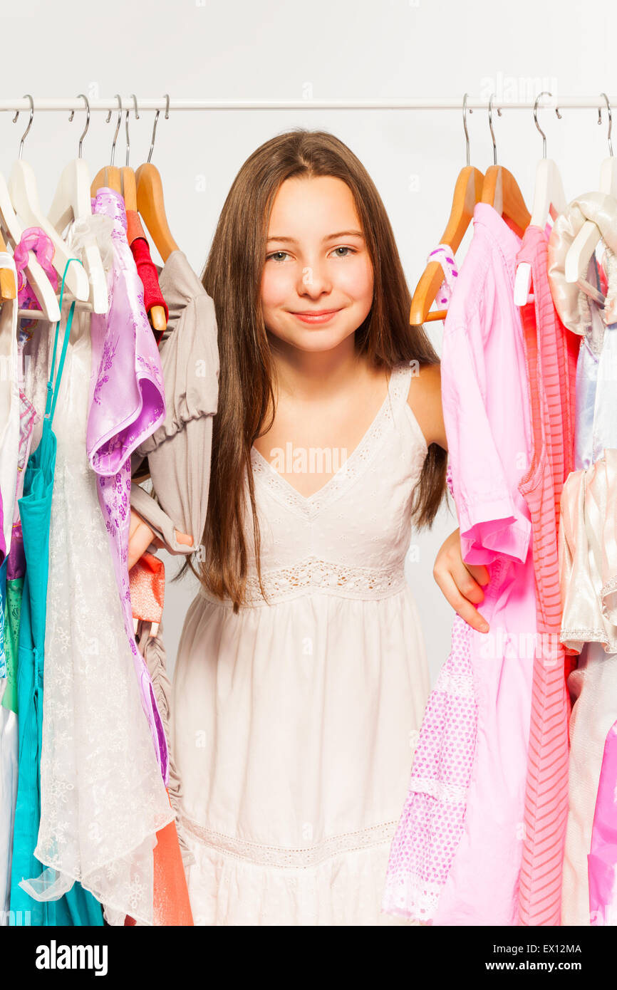 Beautiful girl stands among hangers with clothes Stock Photo Alamy
