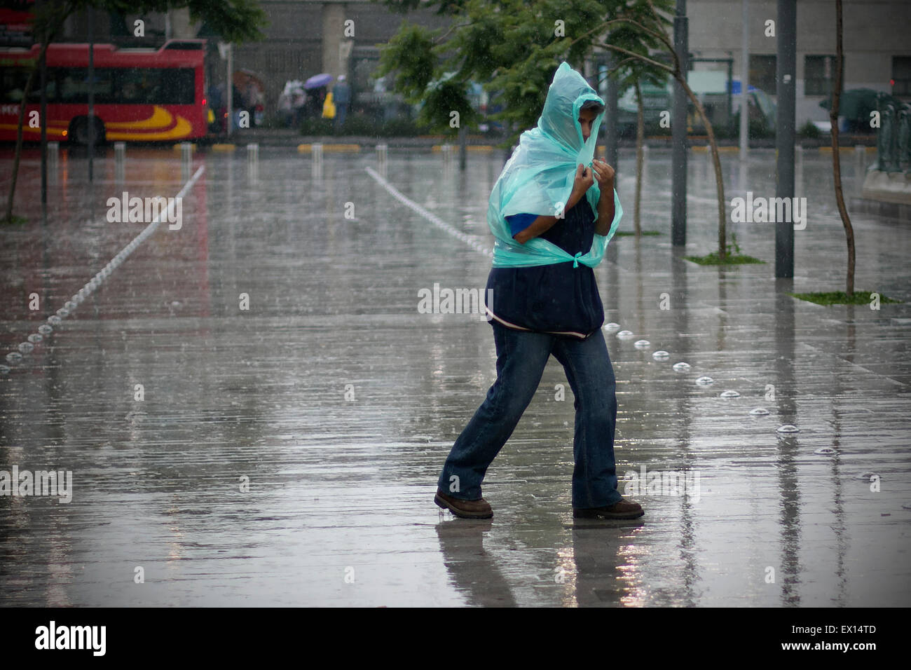 Mexico City, Mexico. 3rd July, 2015. A person walks in the rain in Mexico City, capital of Mexico, on July 3, 2015. According to local press, a low air pressure from the northwest, west and center of Mexico, combined with the entrance of humidity from the Pacific ocean and the Gulf of Mexico, will favor the potential of rains. Credit:  Alejandro Ayala/Xinhua/Alamy Live News Stock Photo