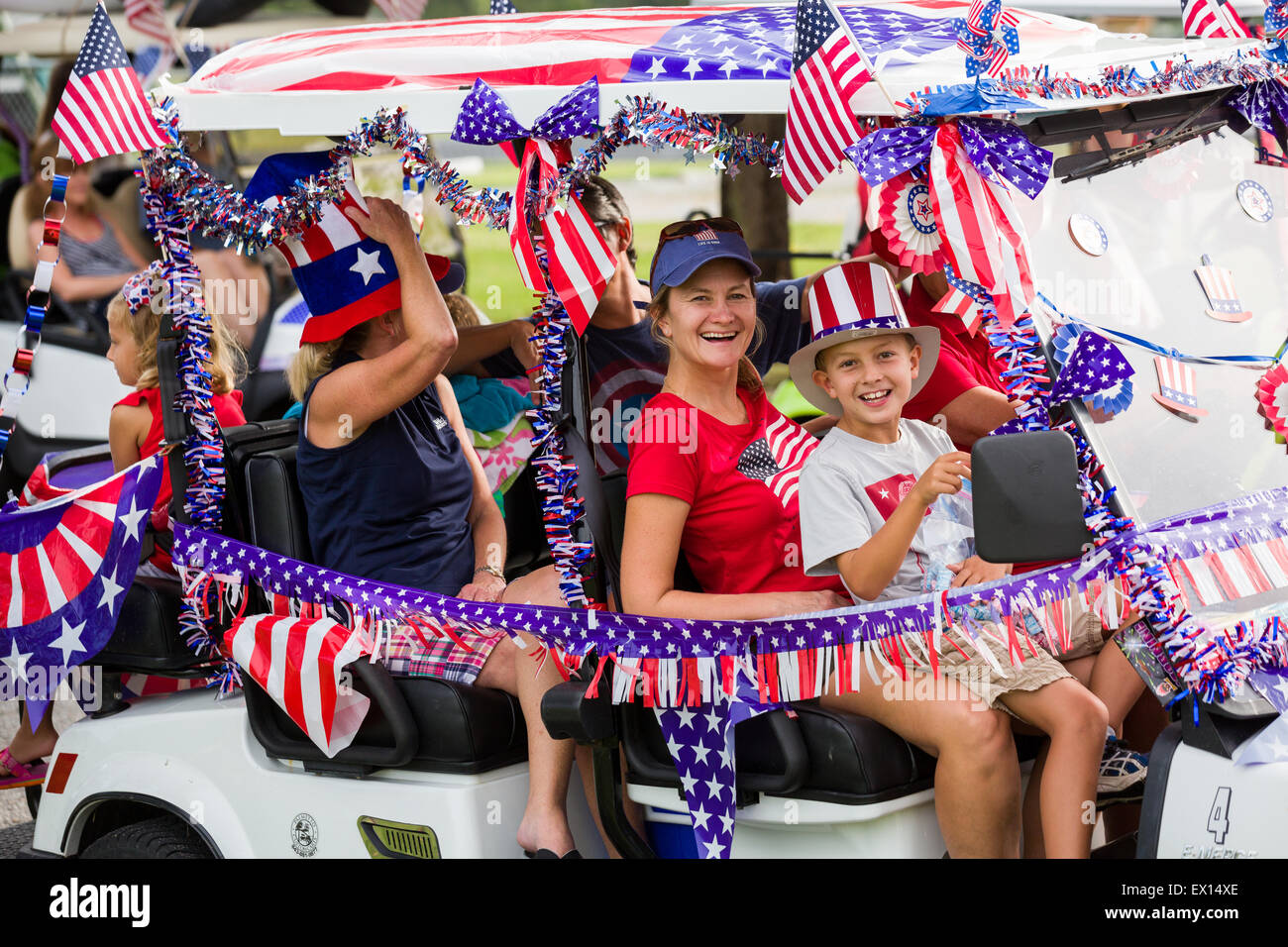 A family rides in their golf cart decorated with bunting and American flags during the Daniel Island Independence Day parade July 3, 2015 in Charleston, South Carolina. Stock Photo