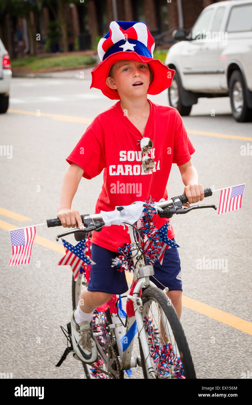 A young boy rides his bicycle decorated with bunting during the Daniel Island Independence Day parade July 3, 2015 in Charleston, South Carolina. Stock Photo