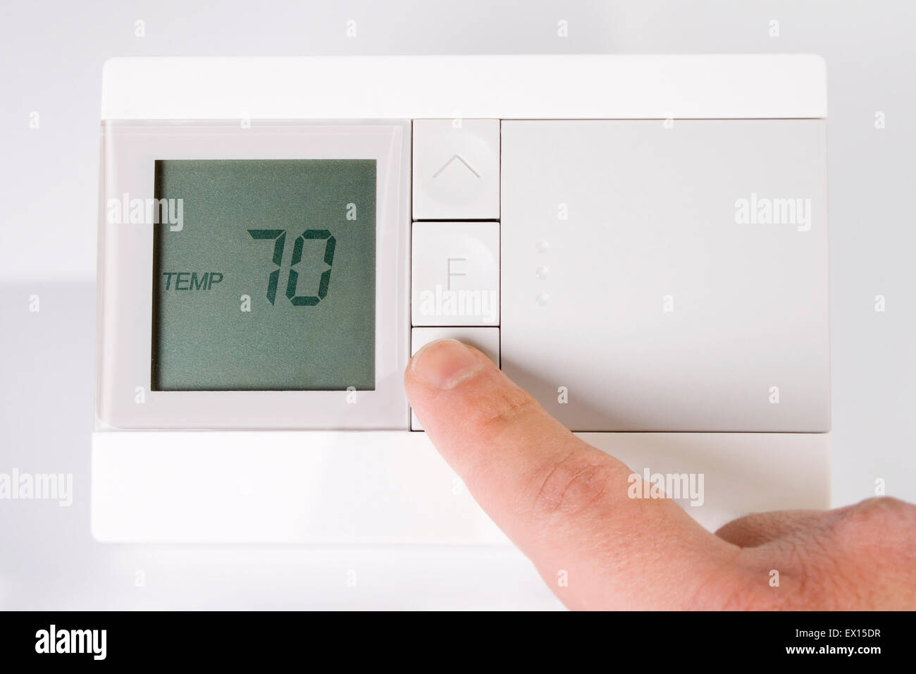 Stock image of hand adjusting thermostat Stock Photo