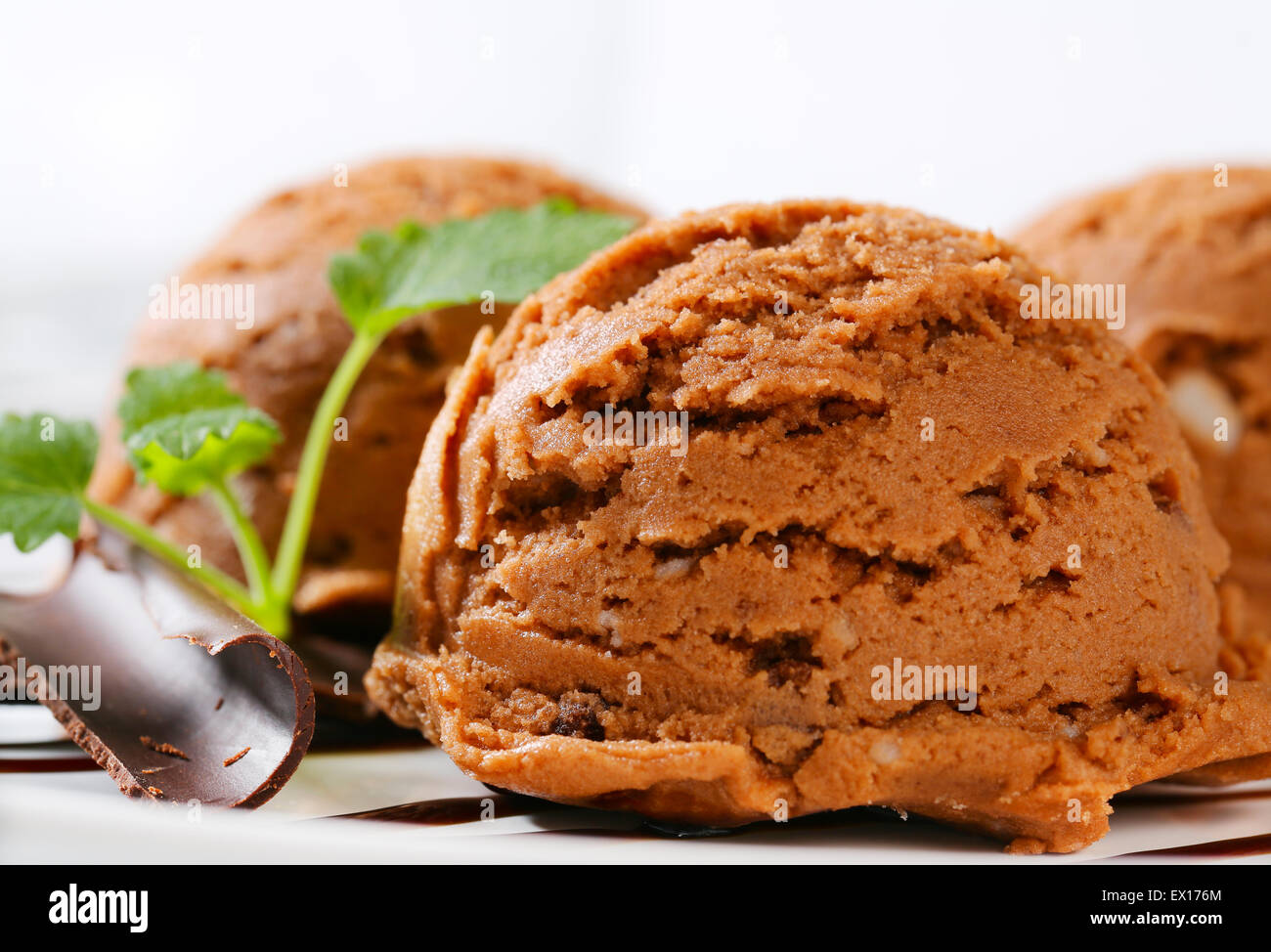 Scoops of brown ice cream with chocolate syrup Stock Photo Alamy