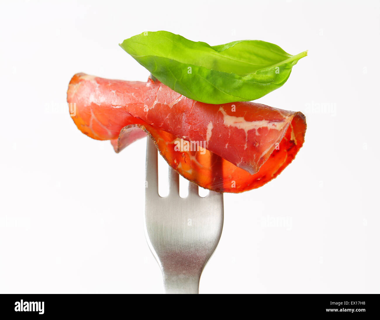 Thin slice of smoked marinated beef on fork Stock Photo