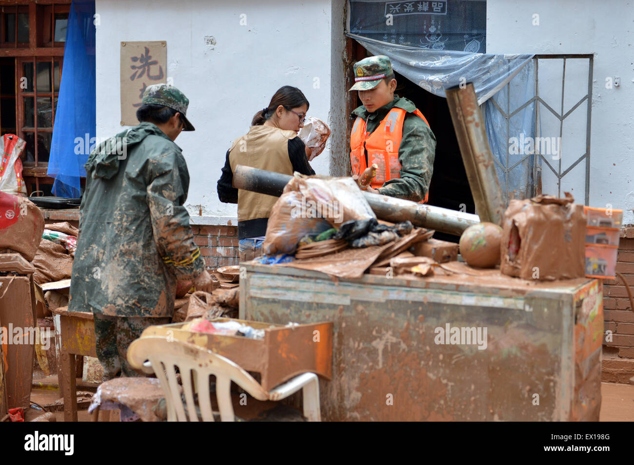 Sunan, China's Gansu Province. 4th July, 2015. Armed policemen transfer materials for residents in Sunan County, northwest China's Gansu Province, July 4, 2015. A heavy rainfall caused landslide in Sunan on Saturday, damaging 63 houses. Credit:  Wu Xuefeng/Xinhua/Alamy Live News Stock Photo