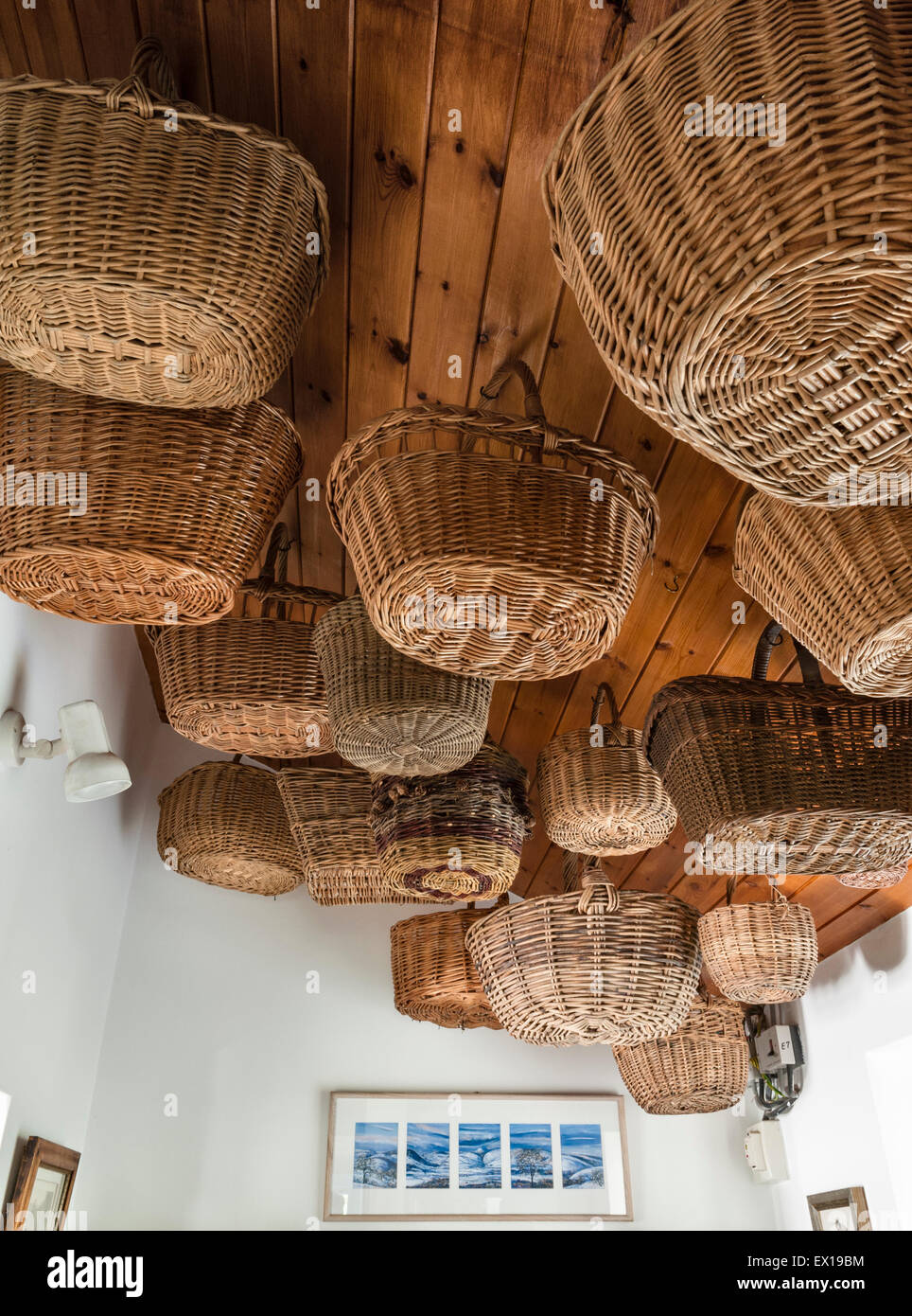 UK. Wicker shopping baskets hung from a ceiling make an attractive decorative feature Stock Photo