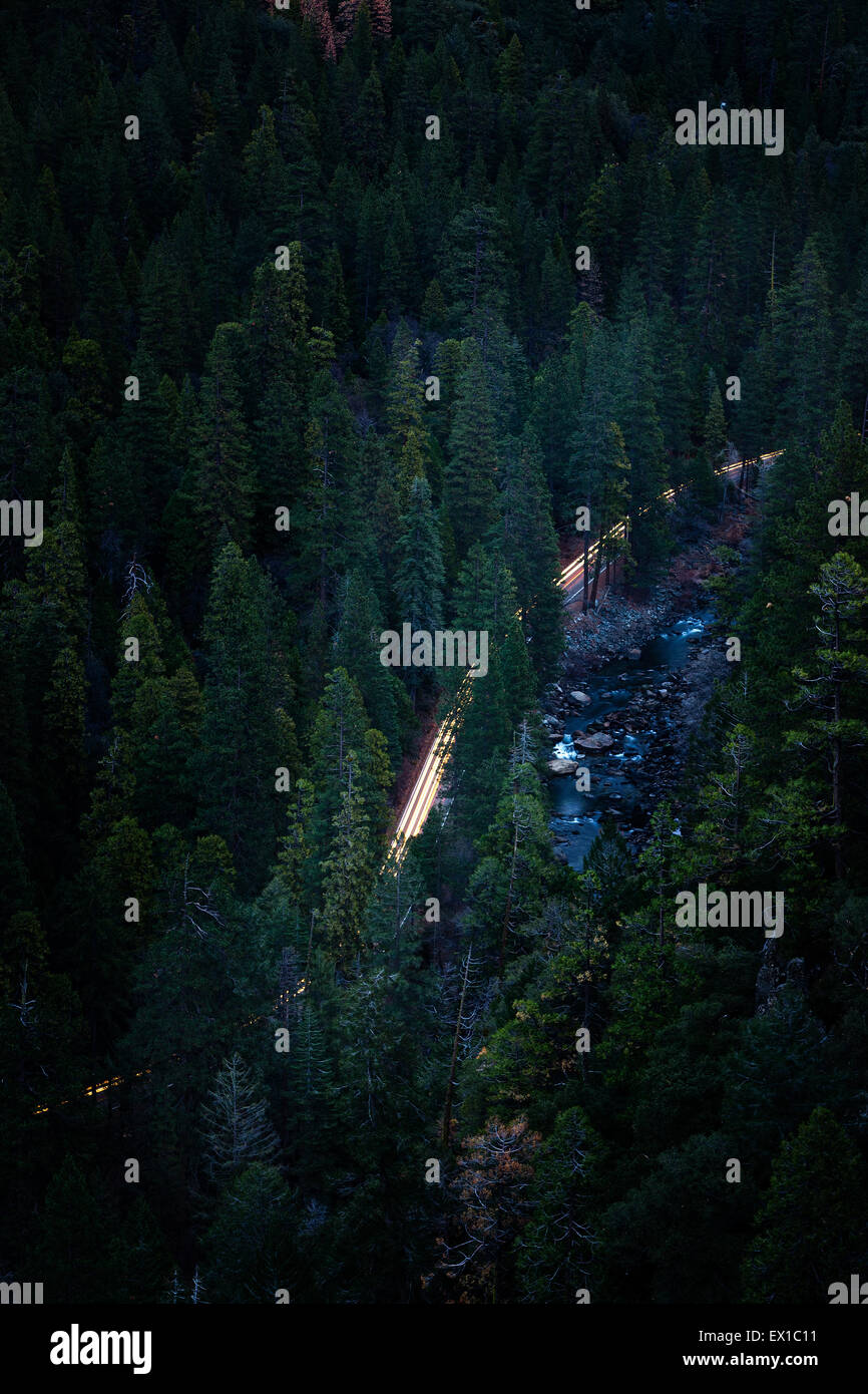 Car headlights at dawn along the Yosemite Valley floor. High shot from above Tunnel View Stock Photo