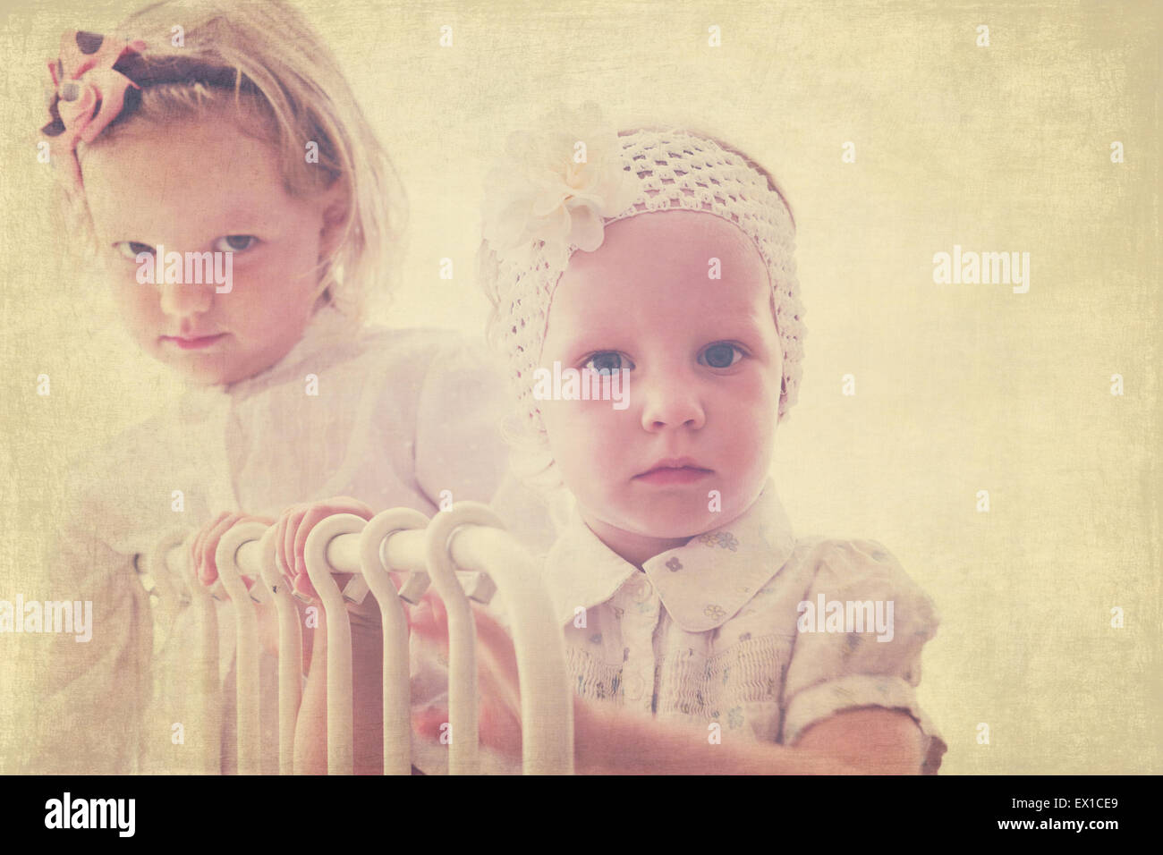 Art photo. Portrait of beautiful little girls (sisters)  in vintage style. The image is tinted, blurring and selective focus. Stock Photo