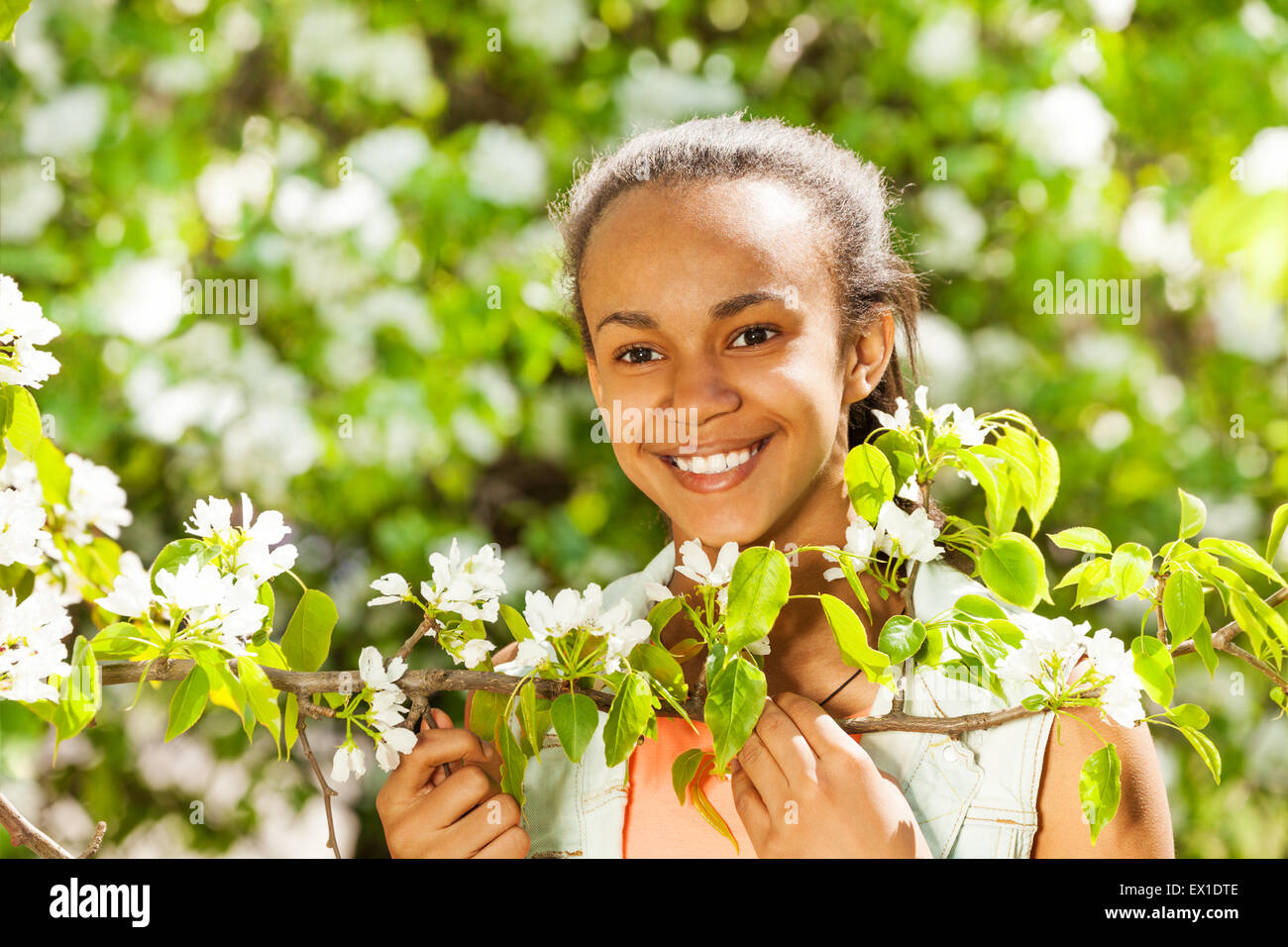 African teenager girl holds white pear flowers Stock Photo