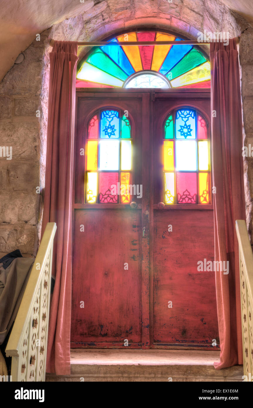 Stained glass entrance door from the inside looks like a big multi-colored lamp Stock Photo