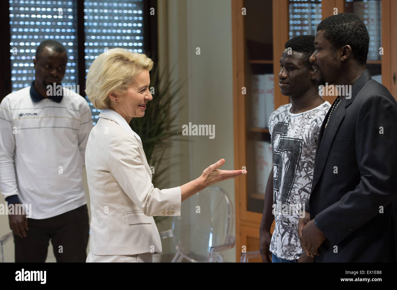 Sicily, Italy. 4th July, 2015. German Defence Minister Ursula von der Leyen (CDU) speaks with refugees from Nigeria and Gambia before her visit to the "Seenotrettung MED" (lit. sea rescue MED) Bundeswehr mission, off the coast of Sicily, Italy, 4 July 2015. Photo: SOEREN STACHE/DPA/Alamy Live News Stock Photo