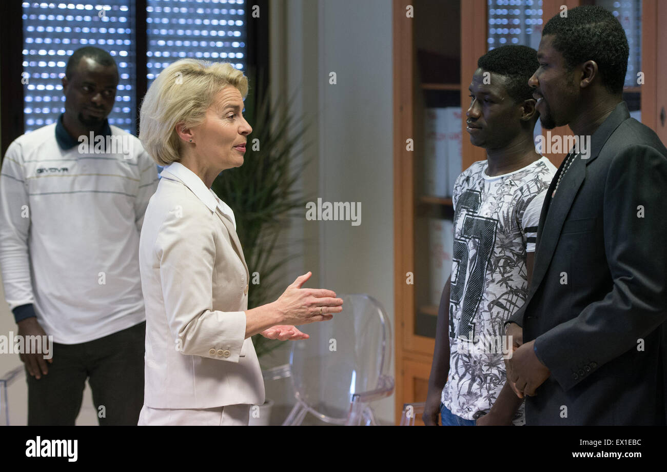 Sicily, Italy. 4th July, 2015. German Defence Minister Ursula von der Leyen (CDU) speaks with refugees from Nigeria and Gambia before her visit to the "Seenotrettung MED" (lit. sea rescue MED) Bundeswehr mission, off the coast of Sicily, Italy, 4 July 2015. Photo: SOEREN STACHE/DPA/Alamy Live News Stock Photo