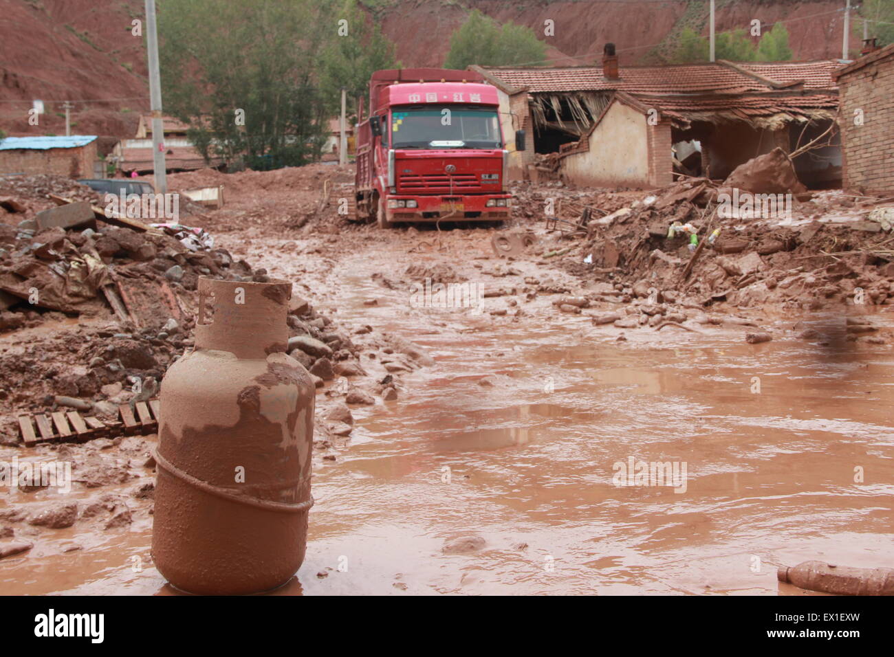 Zhangye, China's Gansu Province. 4th July, 2015. Damaged houses and vehicles are seen in Sunan County, northwest China's Gansu Province, July 4, 2015. A heavy rainfall caused landslide in Sunan on Saturday, damaging 63 houses. Seventy residents have been evacuated. Credit:  Cheng Xuelei/Xinhua/Alamy Live News Stock Photo