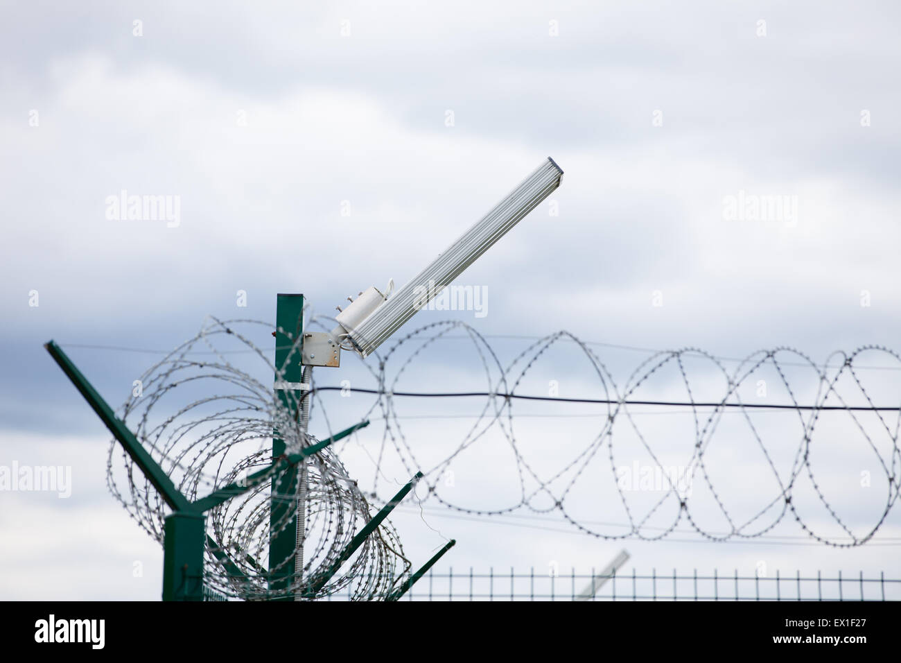 Wired fence with rolled barbed wires on white background Stock Photo ...