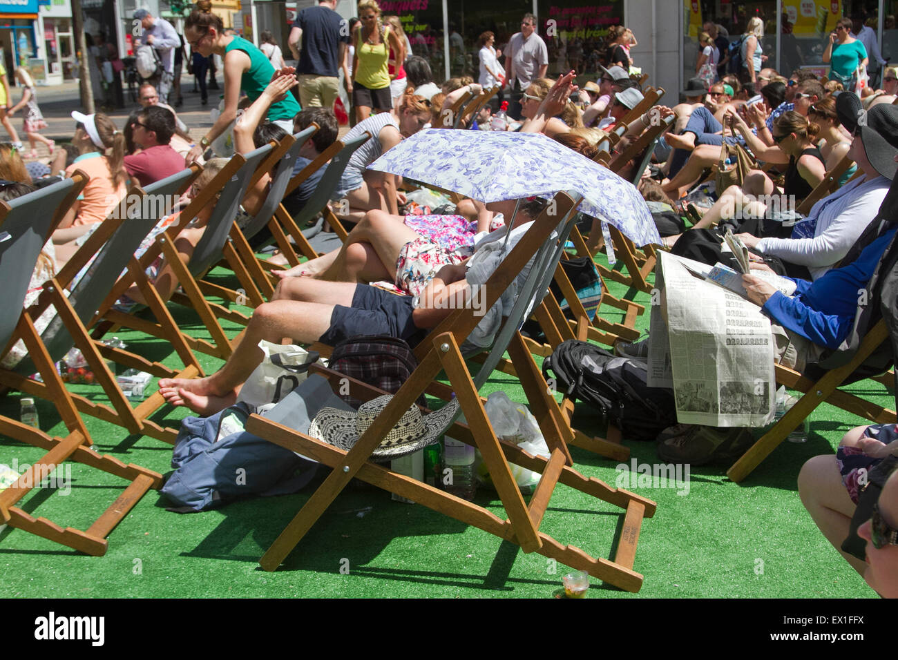 Wimbledon, London, UK. 04th July, 2015. People watch a live tennis match between Roger Federer and Sam Groth on big screens in Wimbledon town centre Credit:  amer ghazzal/Alamy Live News Stock Photo