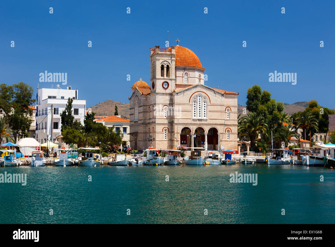Virgin Mary church near Aegina fishboat harbor against a blue sky in Aegina island, Greece Stock Photo