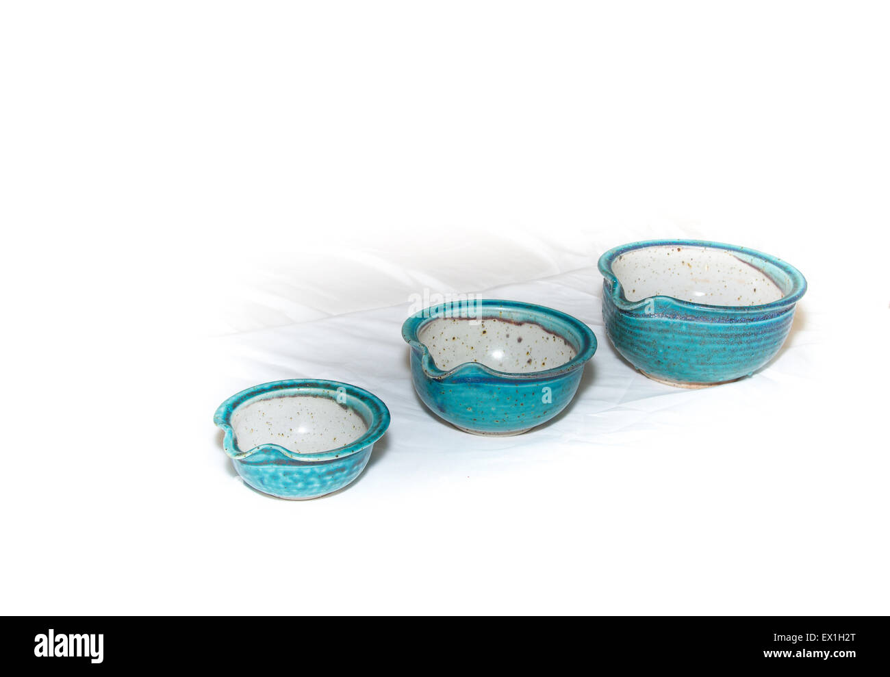 Three blue / aqua pottery empty bowls on a white background Stock Photo