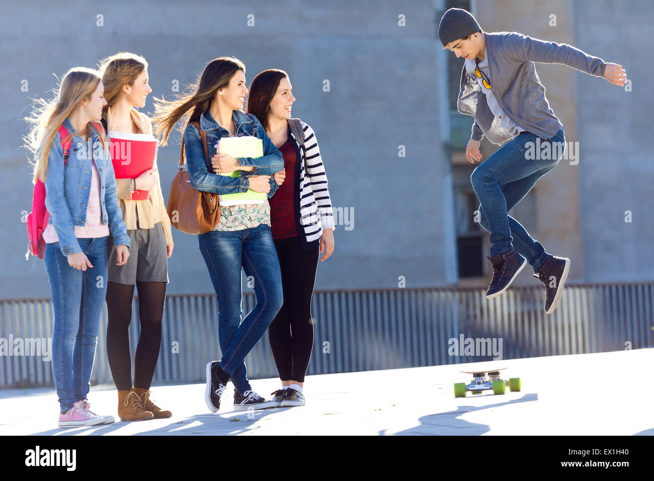 A group of Friends having fun with skate in the street after school Stock Photo