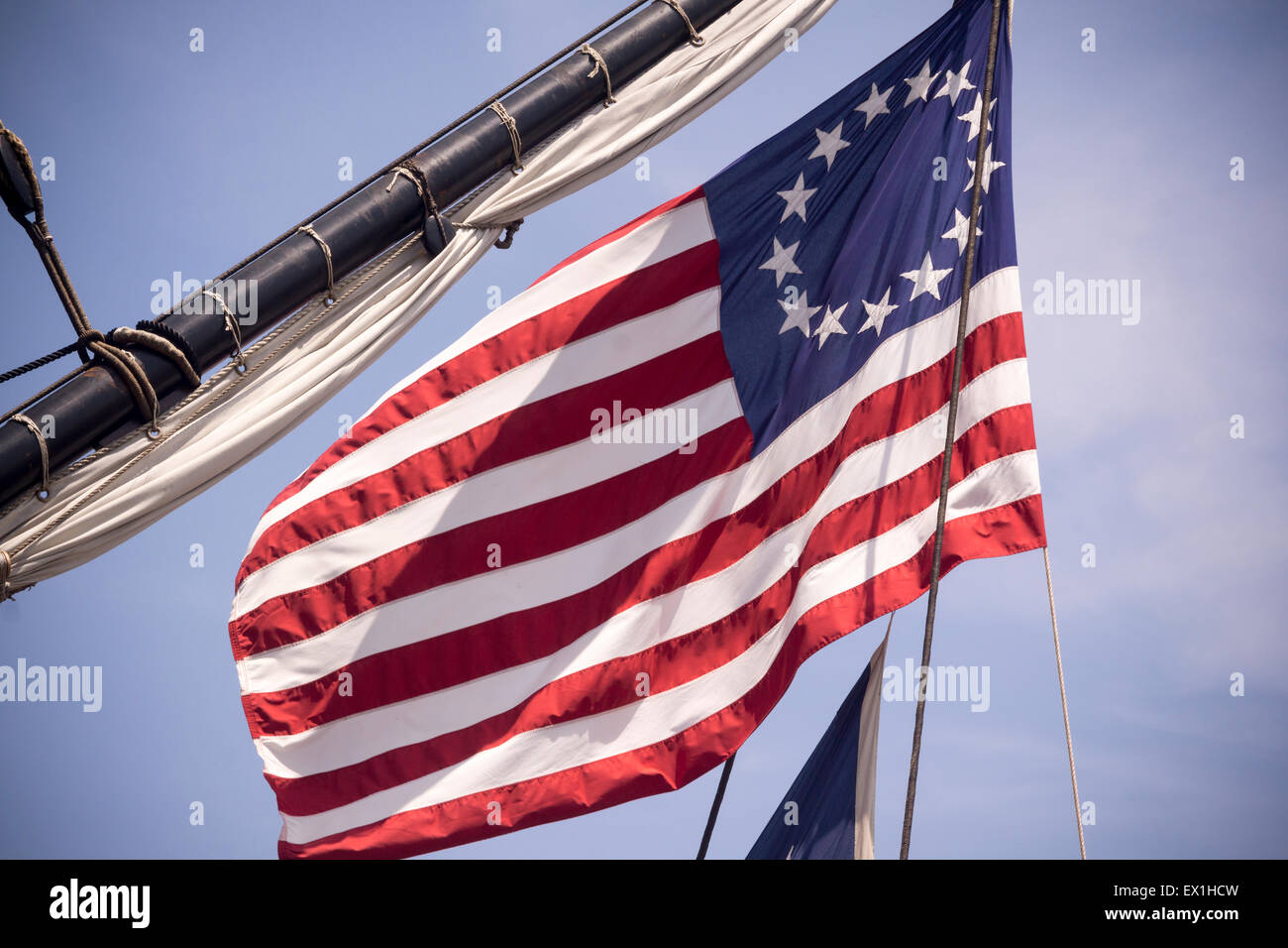 The American flag with thirteen stars representing the thirteen colonies flies from the French frigate L'Hermione berthed on the East River in New York on Friday, July 3, 2015. Hermoine is a replica of the 18th century frigate that brought French General the marquis of Lafayette to America to assist in the war of independence from Britain. It will take part in the July 4th festivities and continue its travels up the East Coast and onto Canada. (© Richard B. Levine) Stock Photo