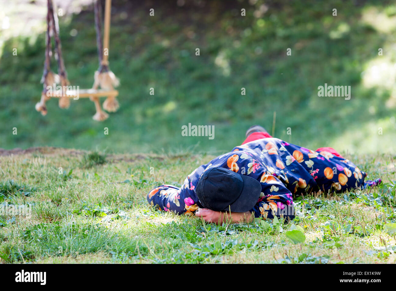 A homeless man is sleeping on a meadow in the center of Sofia. Years after joining the EU Bulgaria is still struggling with grea Stock Photo