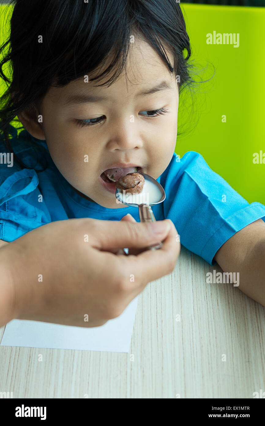 Illness asian kids eating cereal, saline intravenous (IV) on hand Stock Photo