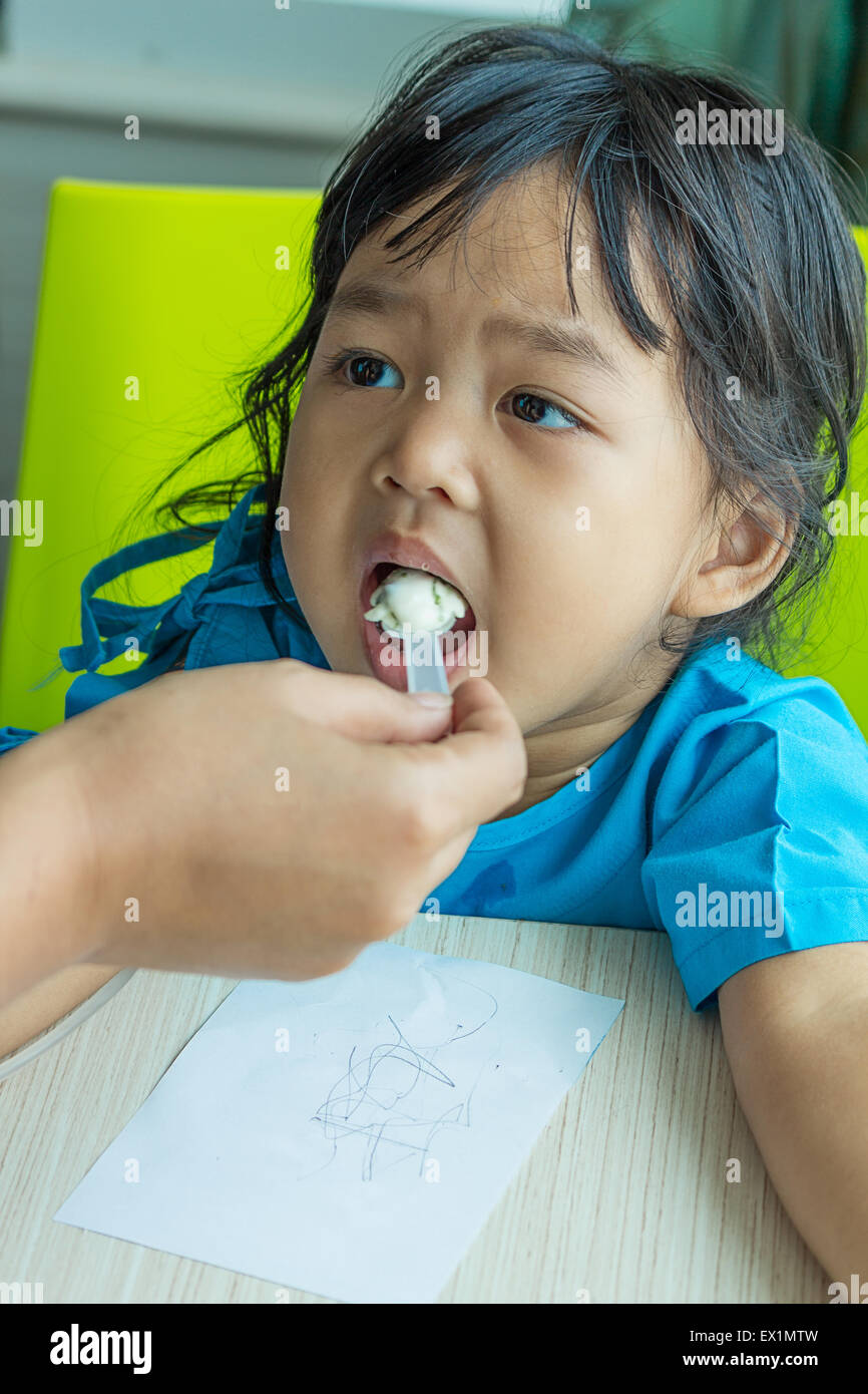Illness asian kids eating cereal, saline intravenous (IV) on hand Stock Photo
