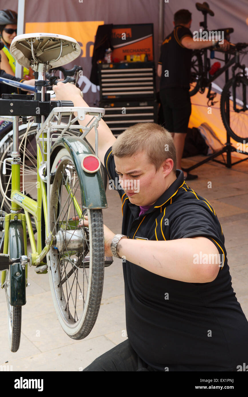 Man adjusting a bicycle while it is held on a mechanics bicycle stand Stock Photo