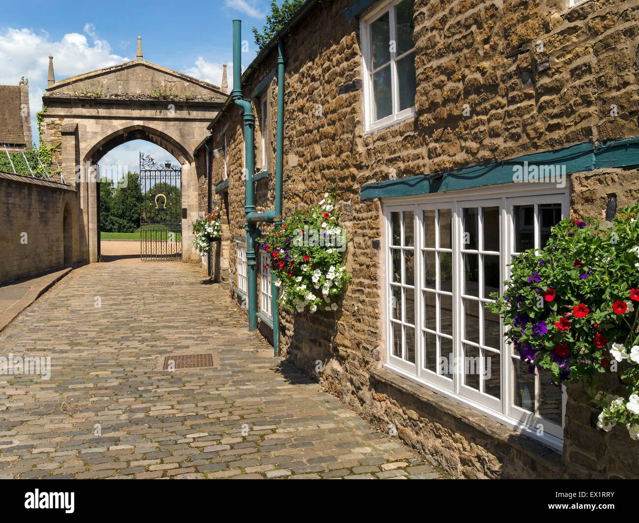 Cobbled street and entrance archway to Oakham Castle grounds, Oakham, Rutland, England, UK. Stock Photo