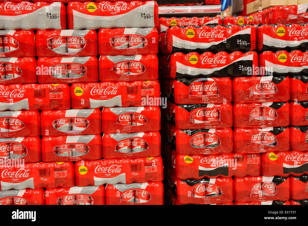 Stacks of cans of Coca Cola in supermarket Stock Photo