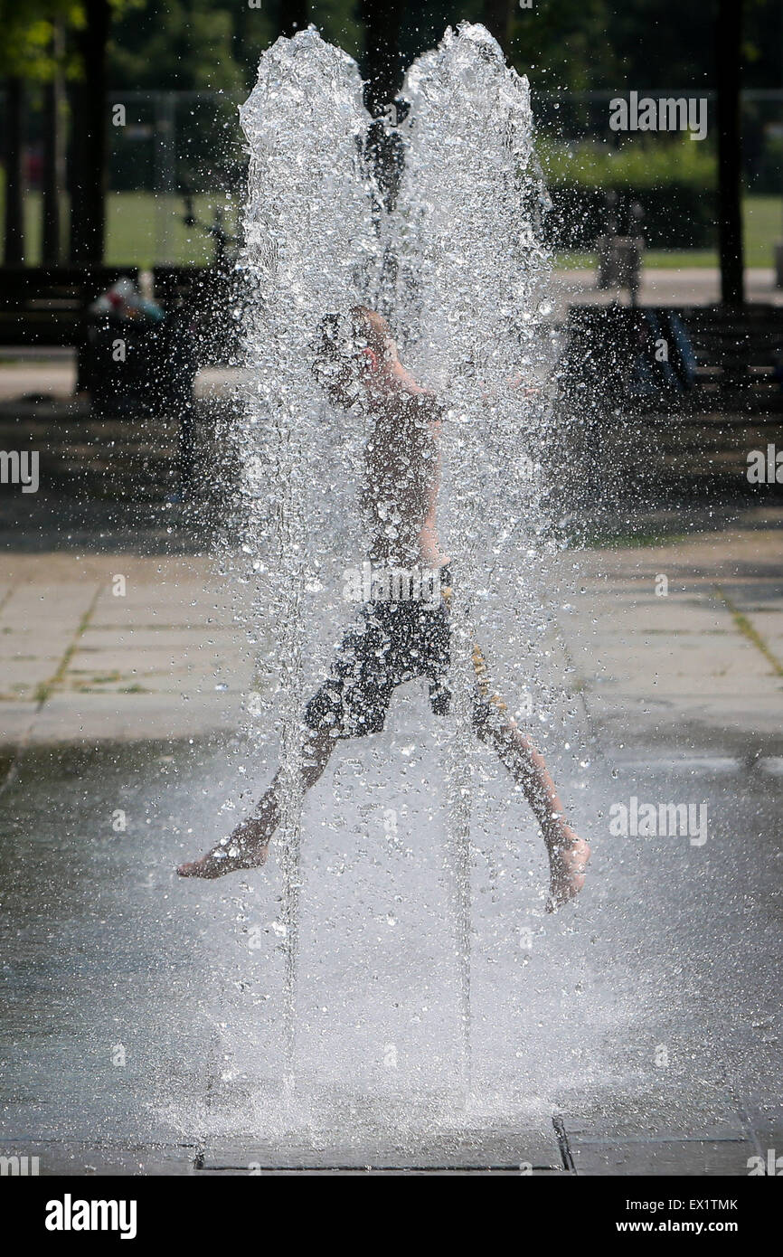 Berlin, Germany. 4th July, 2015. A child plays in a fountain in Berlin, Germany, on July 4, 2015. The temperature in Berlin reached up to 38 degrees Celsius on Saturday. Credit:  Zhang Fan/Xinhua/Alamy Live News Stock Photo