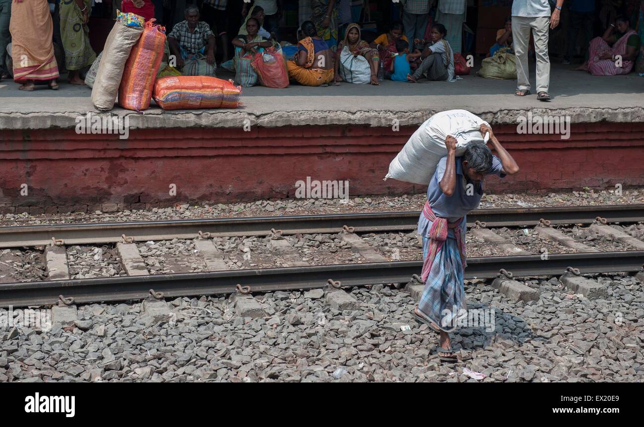 Kolkata, Indian state West Bengal. 4th July, 2015. An Indian village man carries heavy loads in Kolkata, capital of eastern Indian state West Bengal, July 4, 2015. India has released new socio-economic and caste census data which covers the period between 2011 and 2013 to show the wealth, living conditions and other details of the country's 1.2 billion people. Nearly one third are landless, and half derive their income mainly from manual labor. © Tumpa Mondal/Xinhua/Alamy Live News Stock Photo