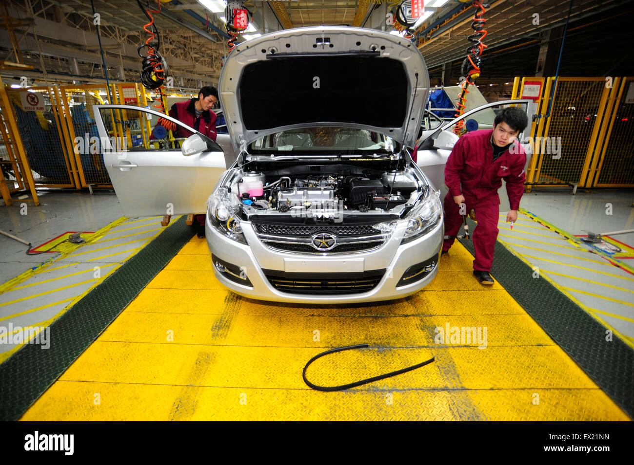 Employees install car doors along the assembly line of Anhui Jianghuai